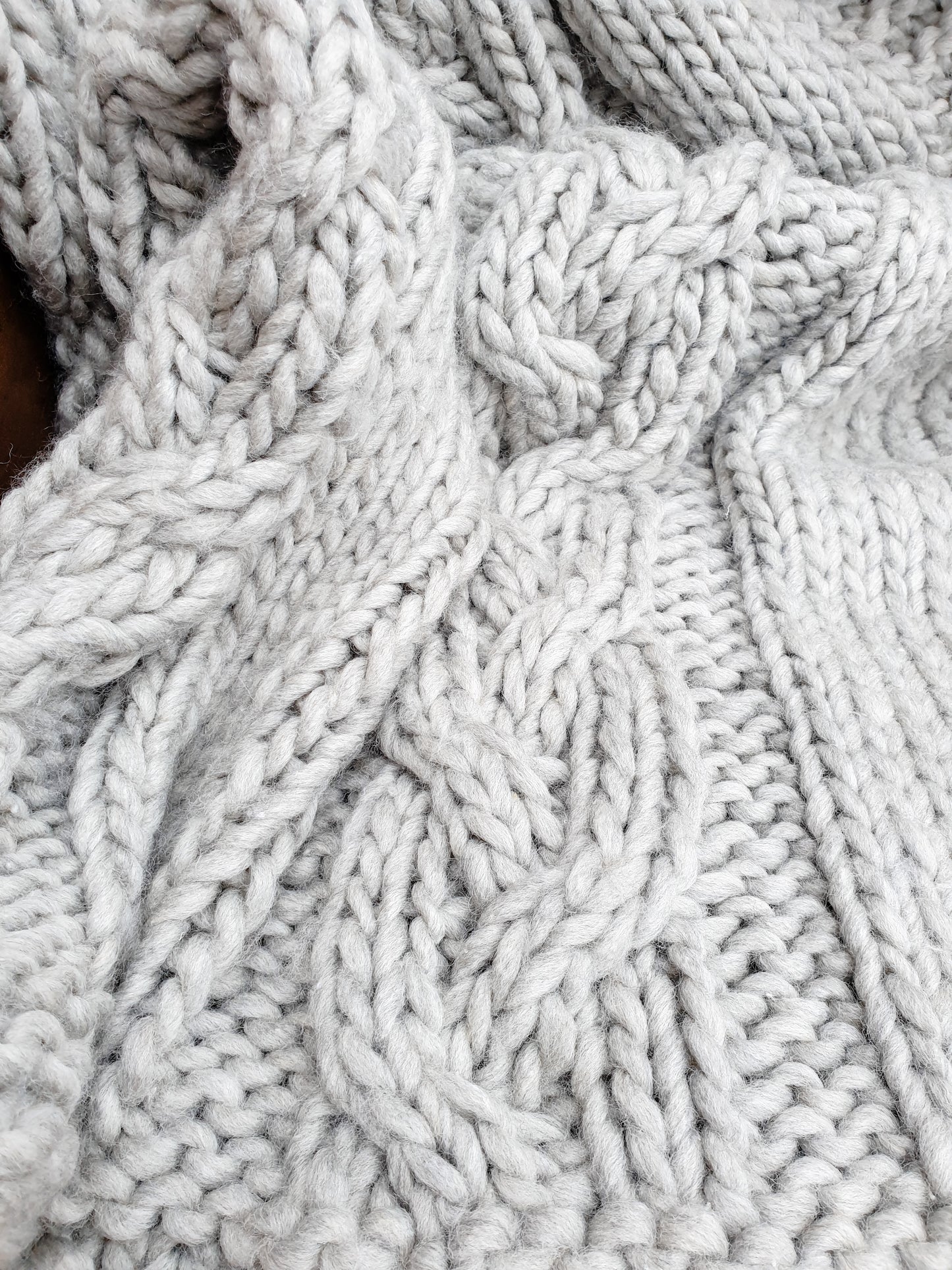 Detail of cable knit on grey throw blanket