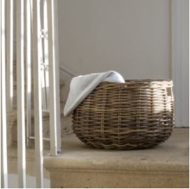 Round rattan blanket basket in sunlight