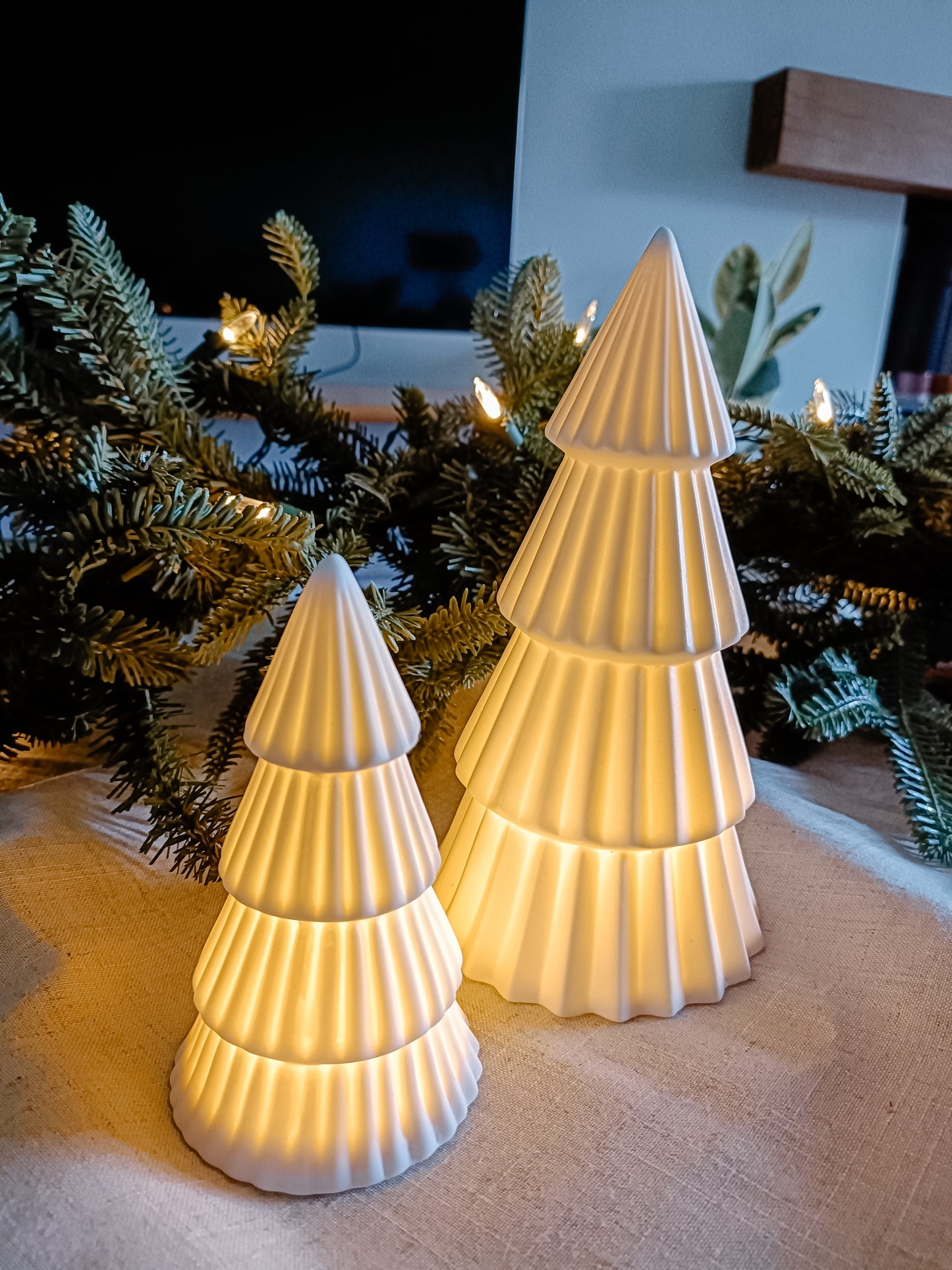 White ceramic Christmas Trees lit up by integrated LED lights