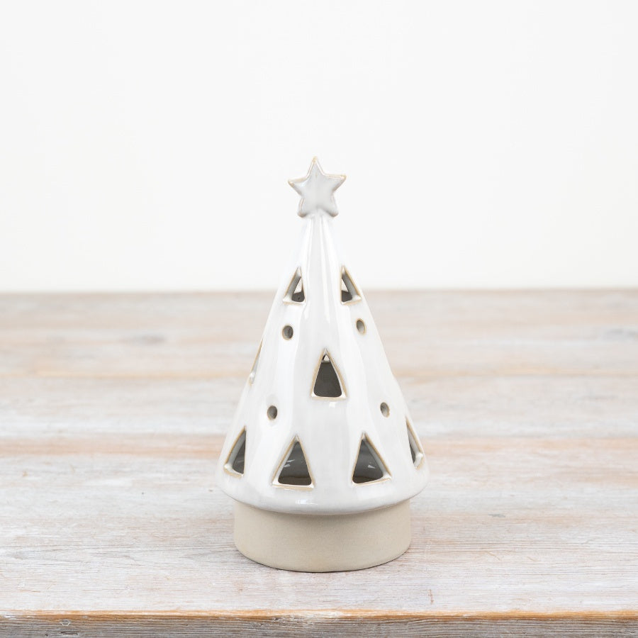 Medium white ceramic Christmas tree with star on top on a wooden surface