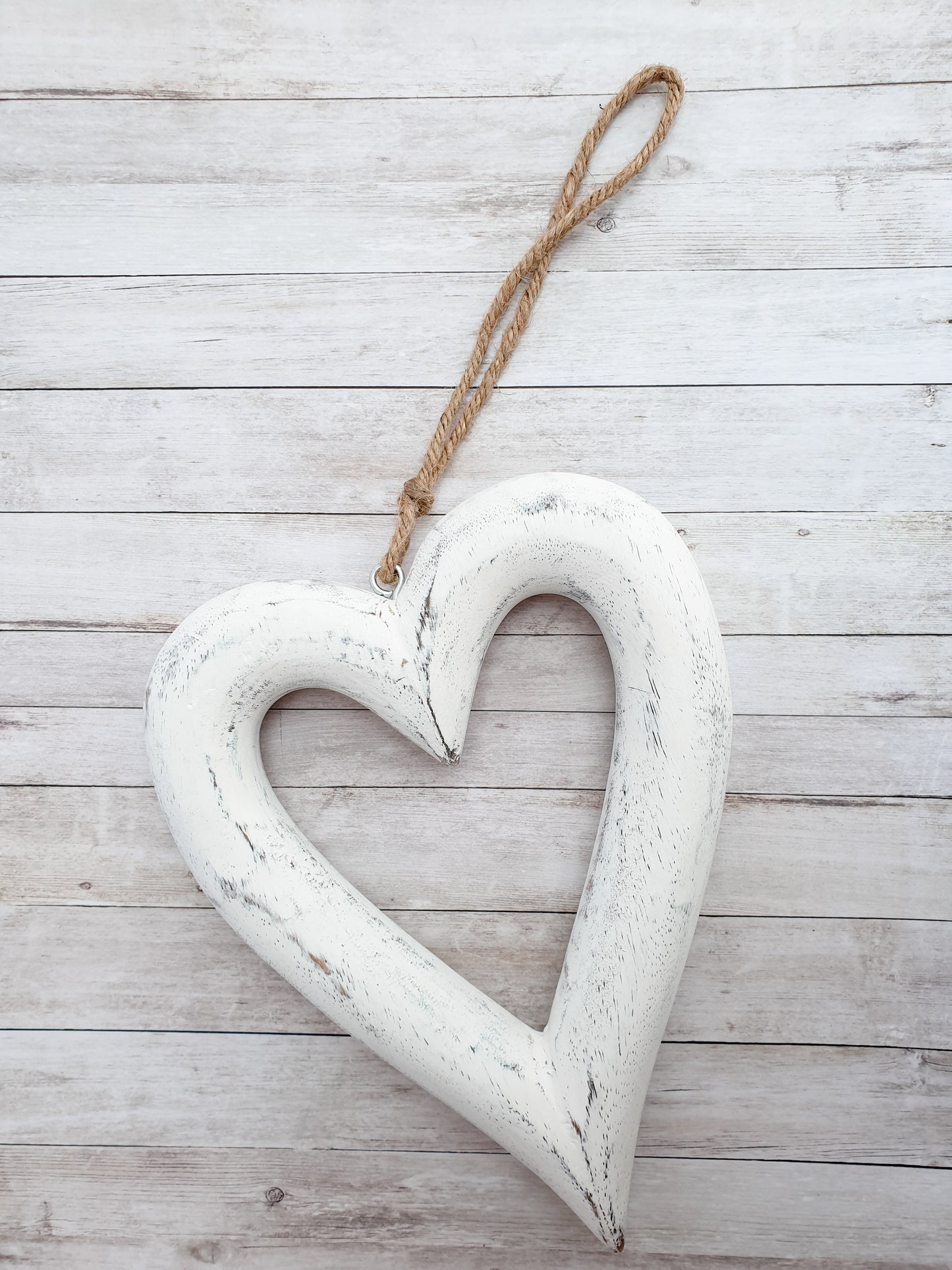 Chunky wooden hanging heart home decor. Perfect accessory for modern country, farmhouse interiors. Add foliage with a ribbon to suit the season or simply enjoy as it is. Shown here on simple rustic wooden backdrop. Perfect home accessory. Great Country inspired home accessory. Great gift idea for country home interior fans.