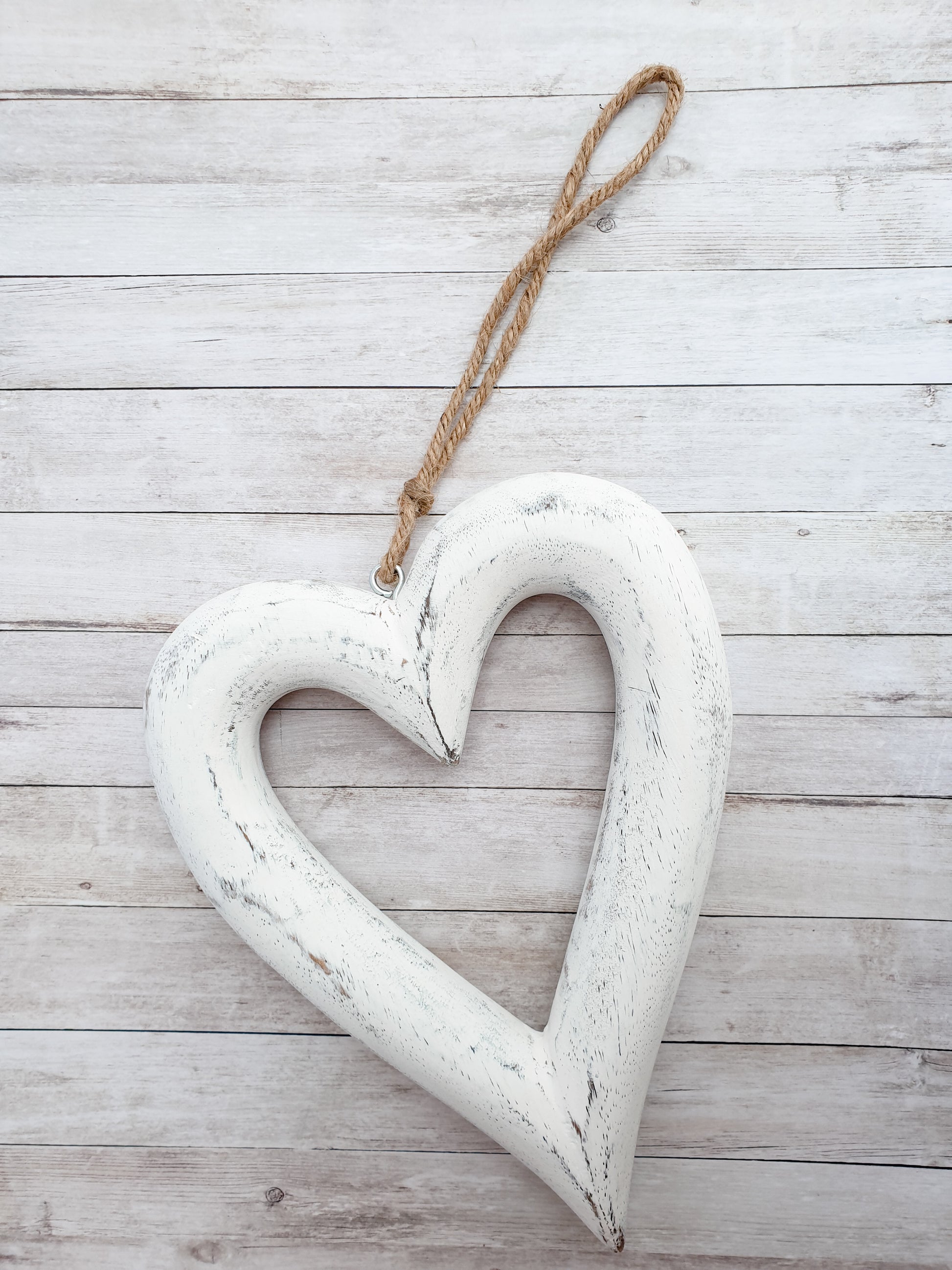 Chunky wooden hanging heart home decor. Perfect accessory for modern country, farmhouse interiors. Add foliage with a ribbon to suit the season or simply enjoy as it is. Shown here on simple rustic wooden backdrop. Perfect home accessory. Great Country inspired home accessory. Great gift idea for country home interior fans.