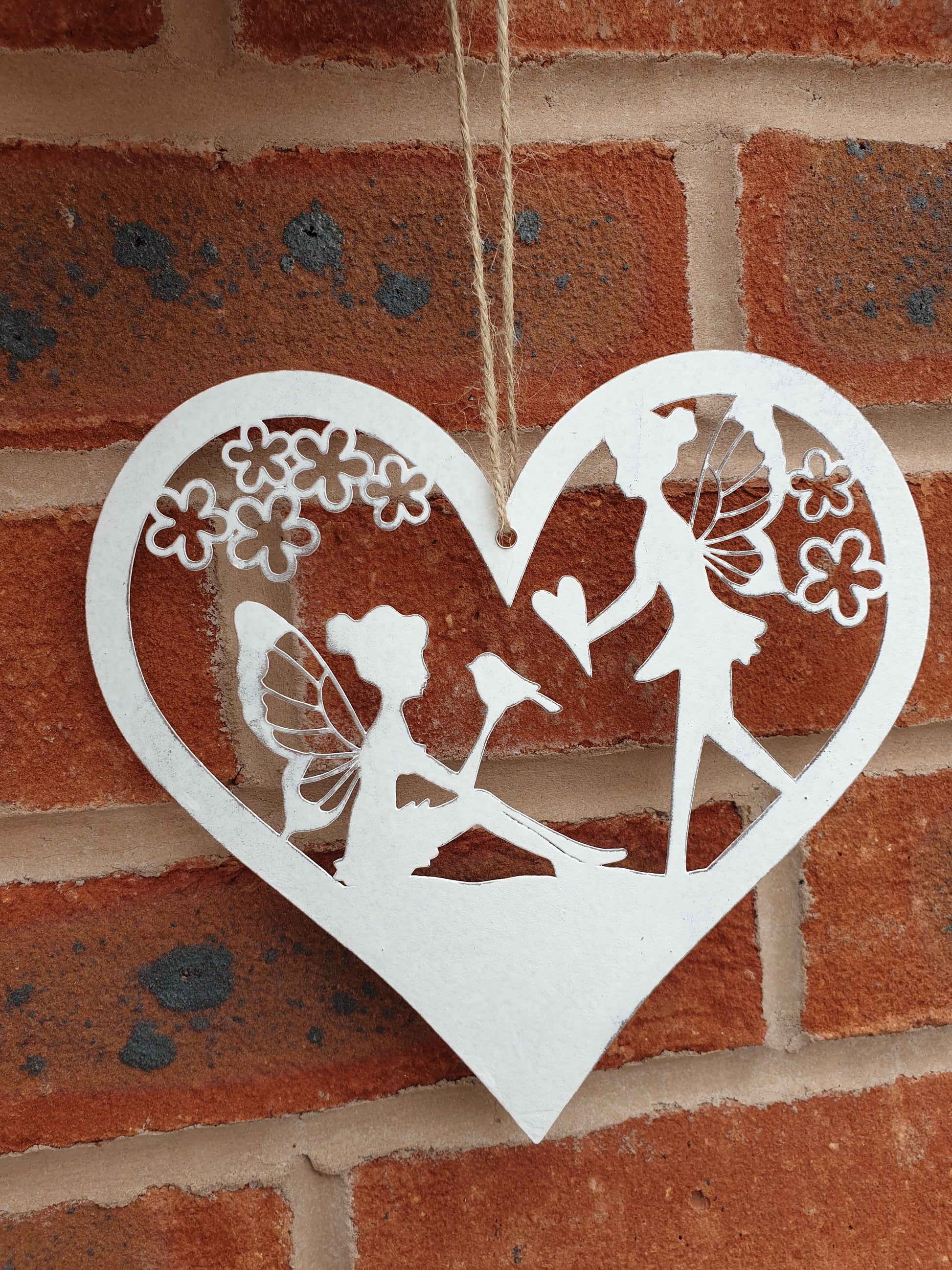 Fairy heart hanger. Metal hanging heart with fairy scene in centre. Beautiful garden decoration for fairy gardens. add magic to your garden wwithour hanging fairy scene heart. pretty whie hanging decoration for the garden. Perfect gift for grandchildren, nieces, nephews, sons and daughters - creating a magical garden for all the family to enjoy.