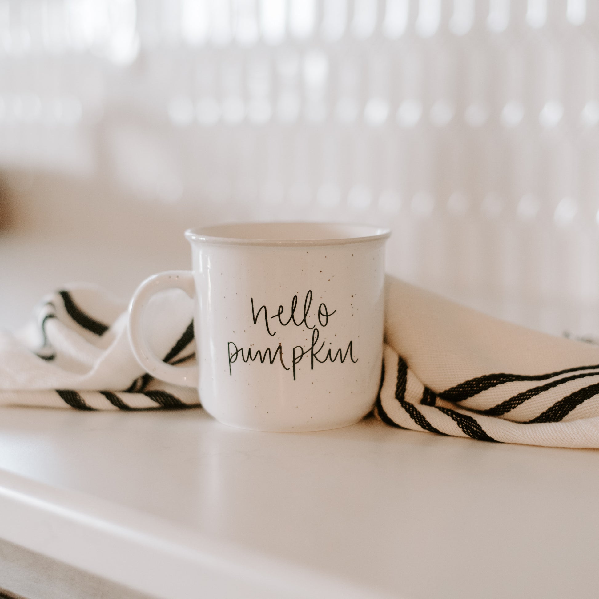 hello pumpkin rustic mug shown with ticking stripe cloth