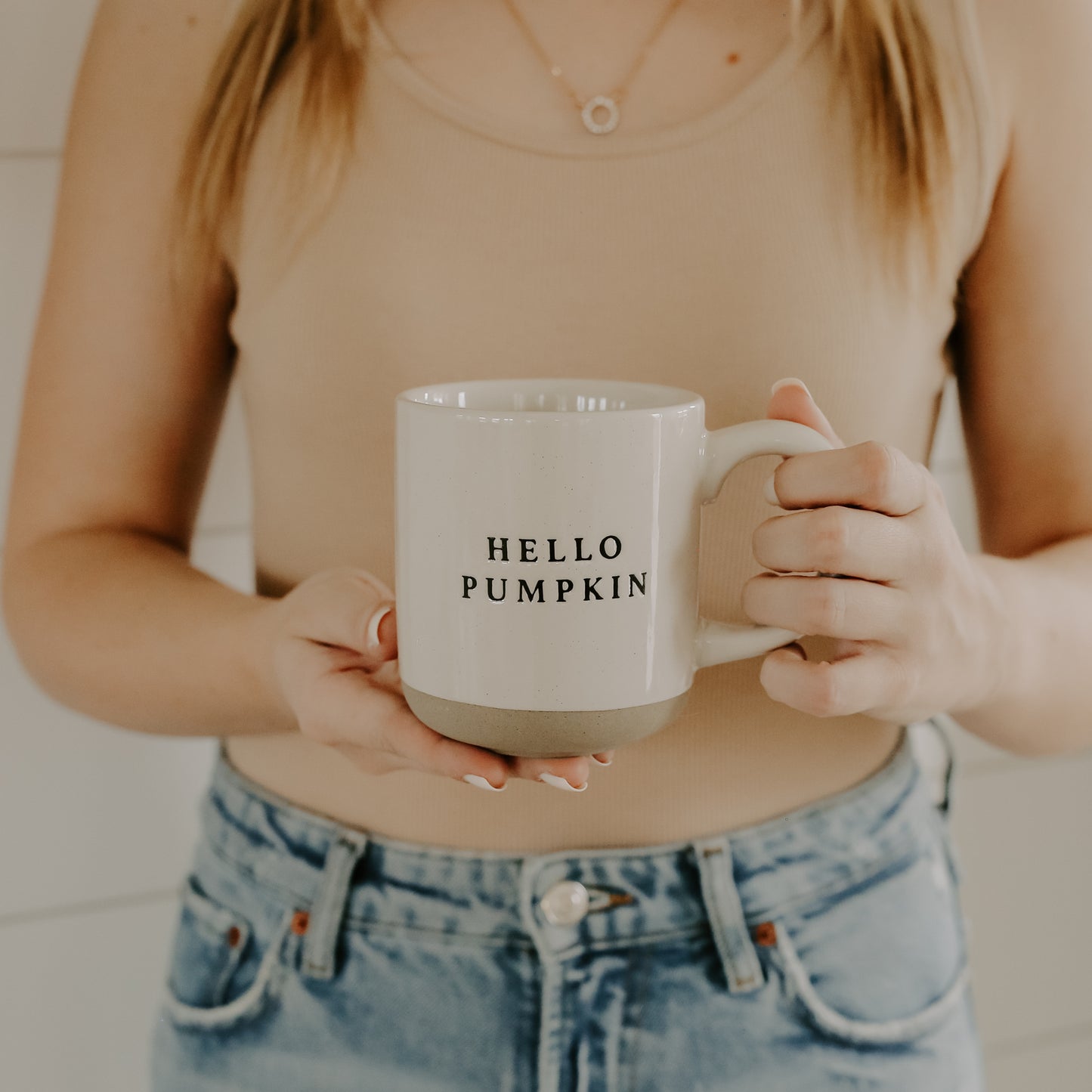 Hello Pumpkin stoneware mug being held to show size.  These part glazed mugs are beautifully tactile and the natual tones blend perfectly with autumn season tones and decor.
