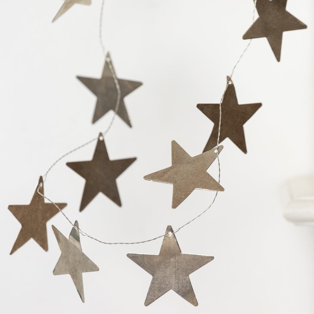 Detailed view of antiqued metal star garland  from Little Wren Interiors
